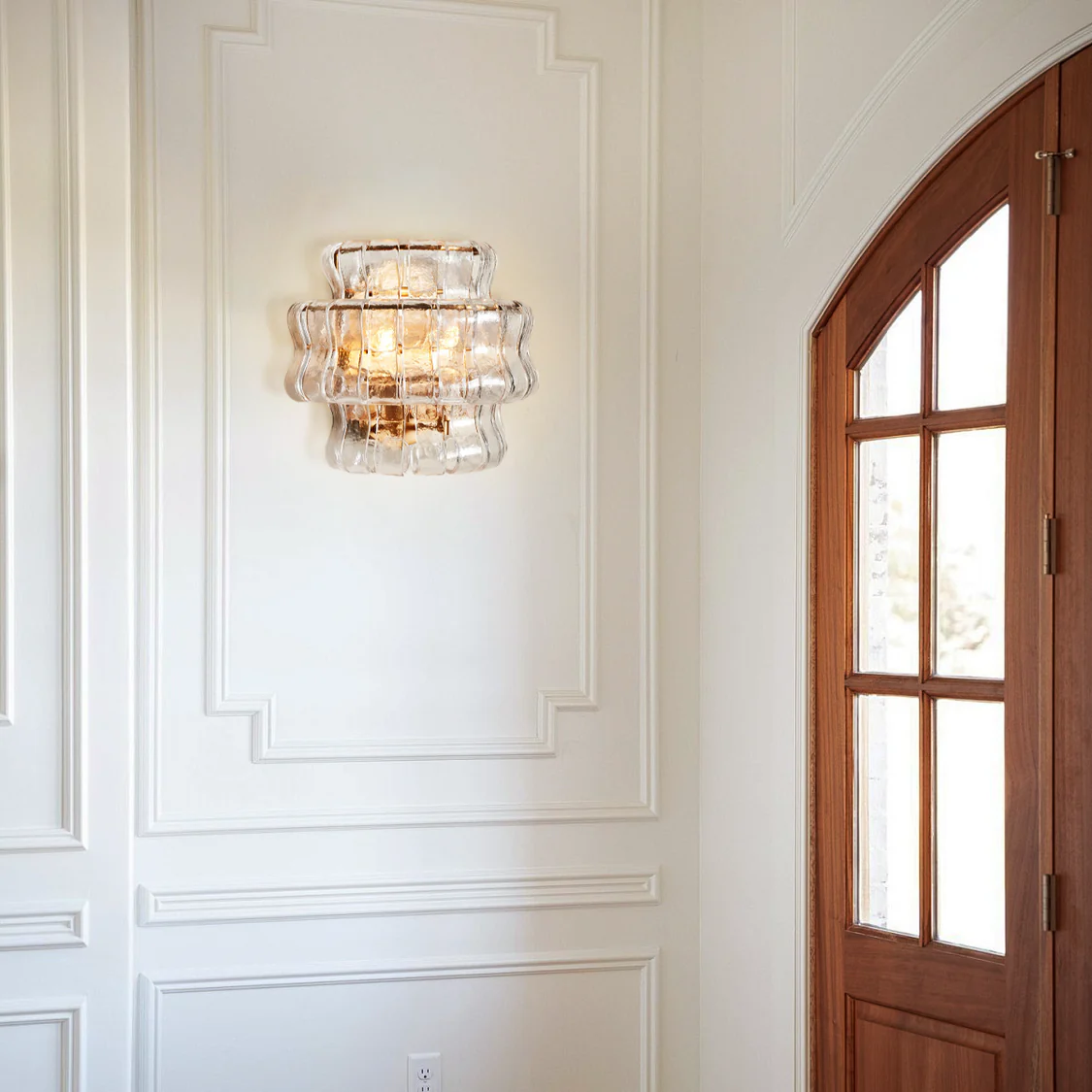 Applique murale avec verre incurvé texturé et finition en laiton pour une lumière chaleureuse dans le salon et la chambre | Sansoti