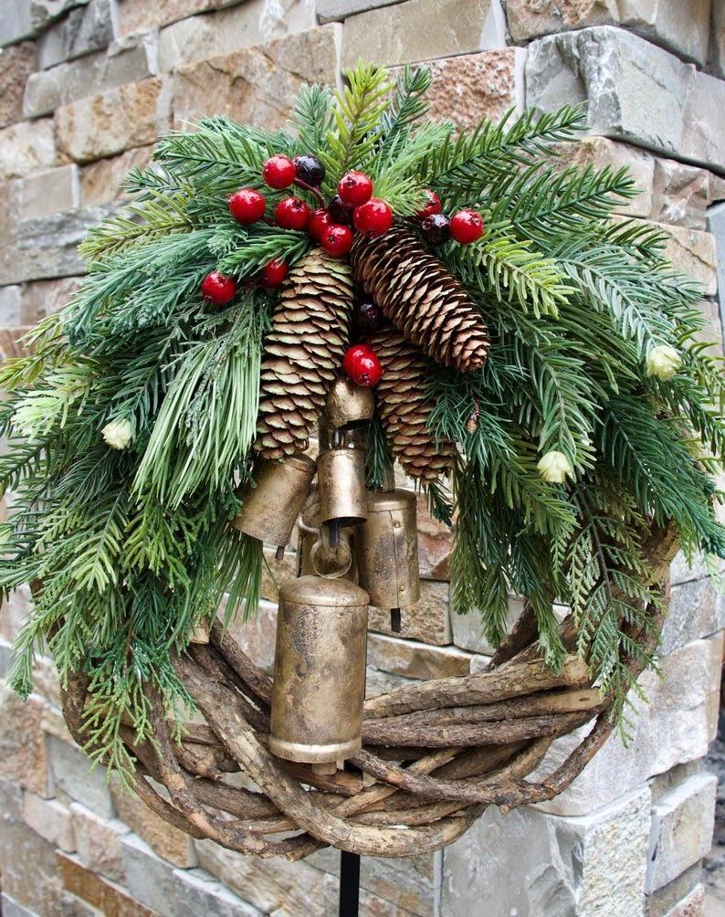 Couronne de Noël rustique avec pommes de pin et clochettes dorées pour décorer la porte et le mur, ambiance festive de Noël | Sansoti