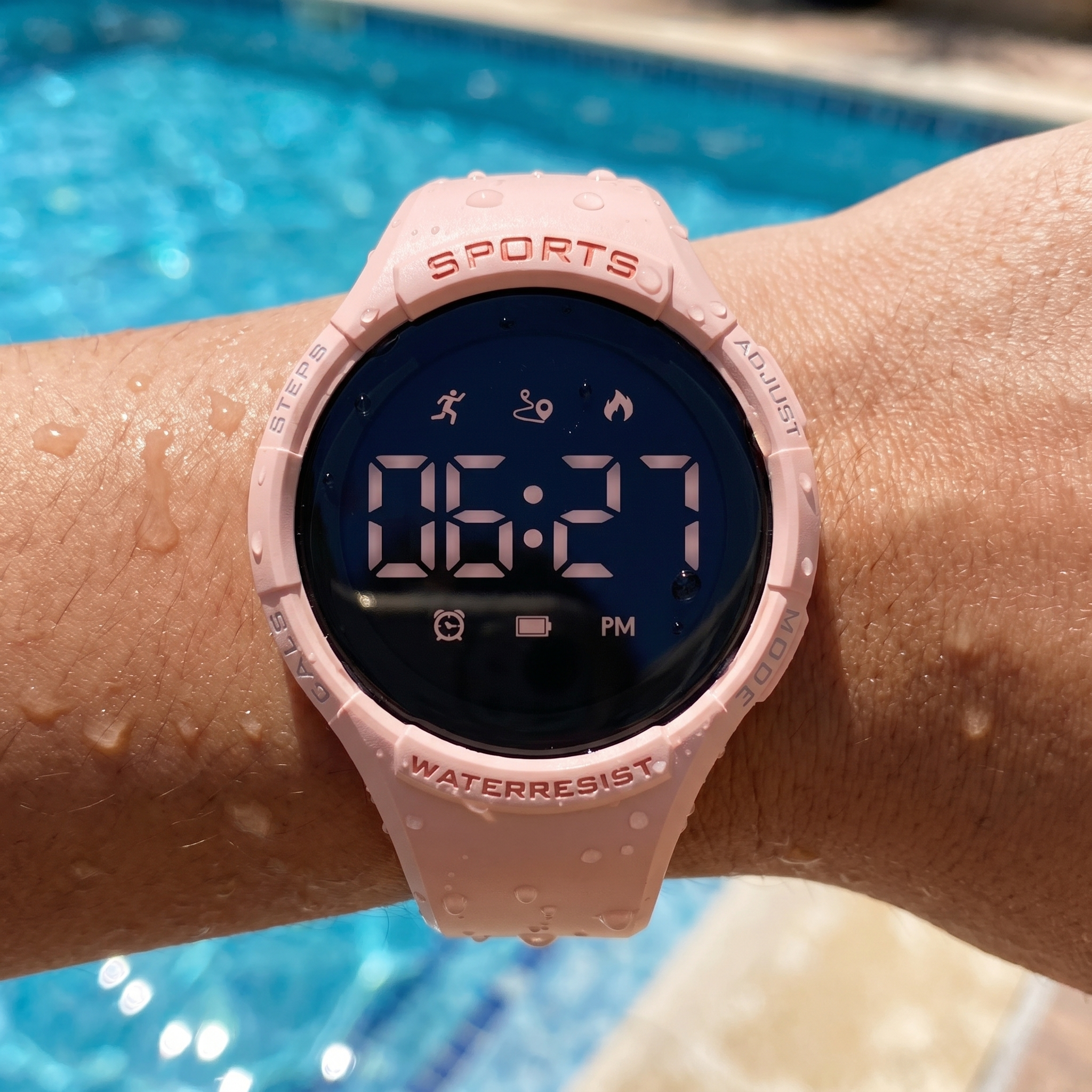 Smartwatch met waterdruppels aan de rand van een zwembad