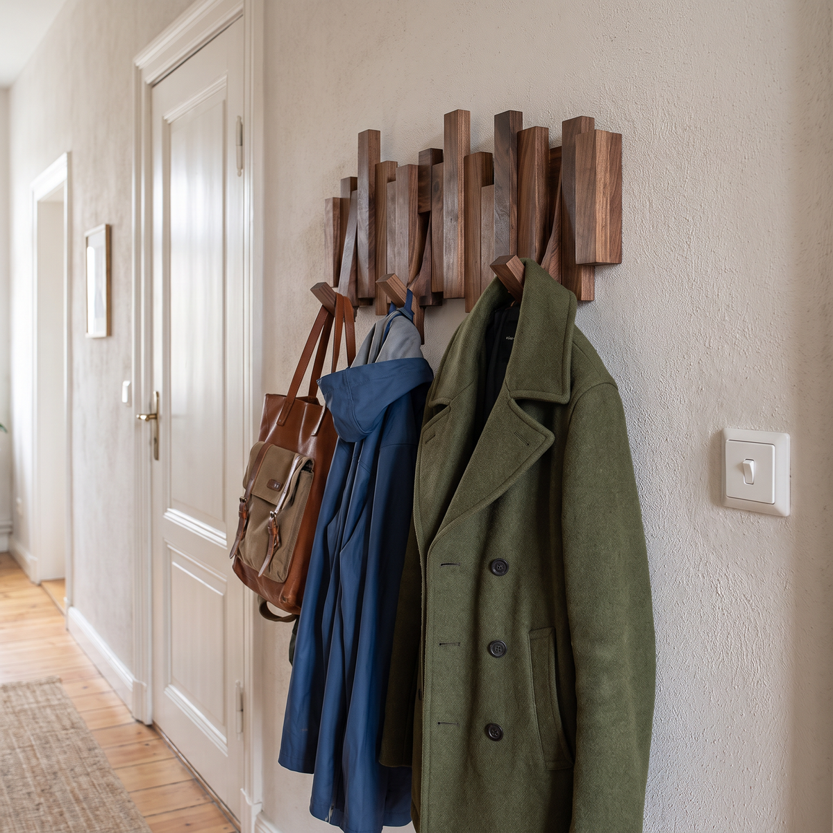 Houten kapstok met tien haken vol jassen in hal
