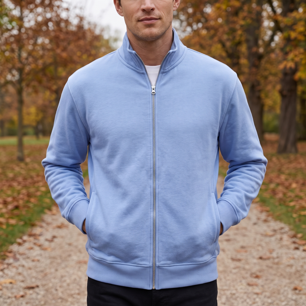 Man in een sportvest met rits op een wandelpad in de herfst