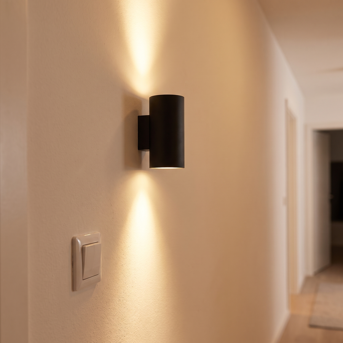 Aluminium up down wandlamp in een gang met warm wit licht langs de muur