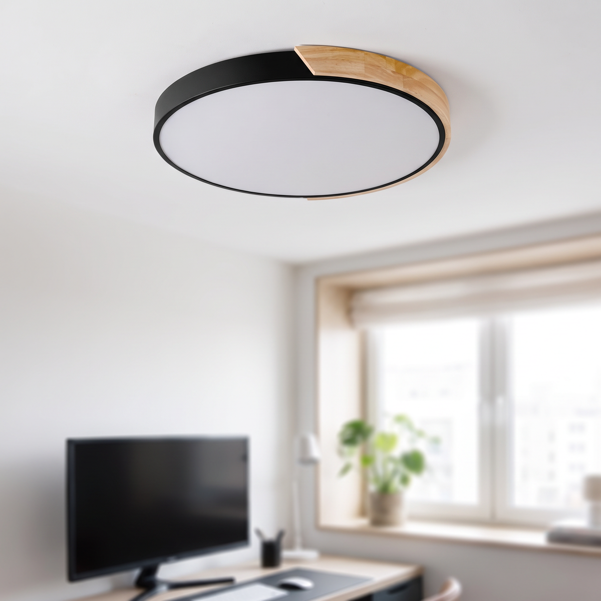 Zwarte ronde macaron plafondlamp van 30 cm boven een bureau